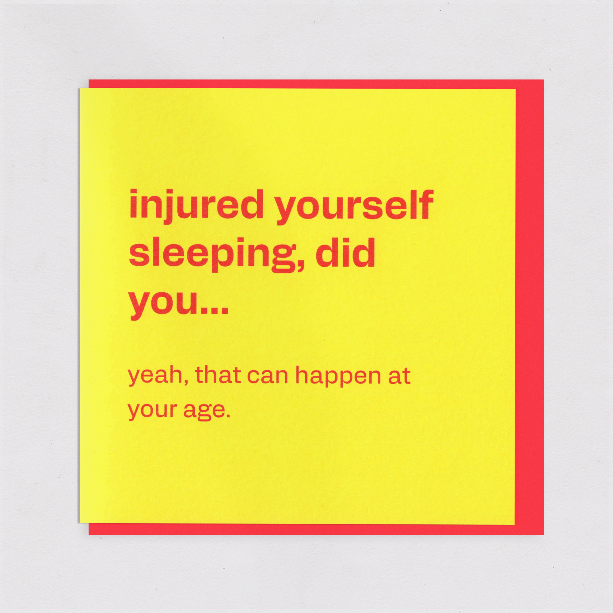 Injured Yourself Sleeping - Funny Ageing Birthday Card, the front of the card, photographed straight on.